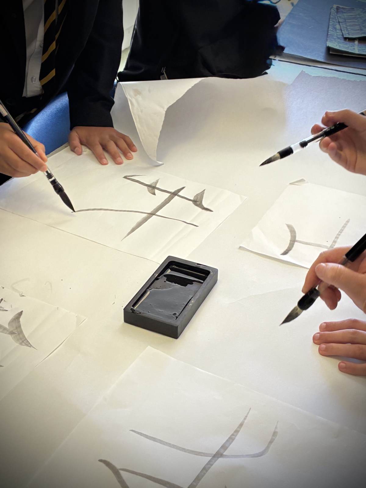 Hands writing traditional Chinese calligraphy